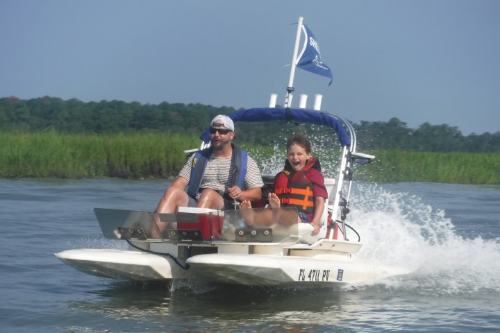 a man riding on the back of a boat in a body of water